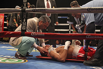 Angel Osuna is attended to doctors in a boxing ring following a serious injury.