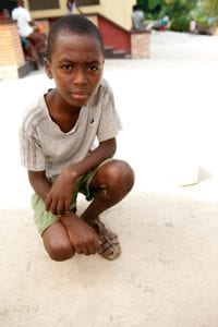 Kneeling boy: In a tent city in the Diquini neighborhood of Port-au-Prince. He was carrying water back to his family’s tent.