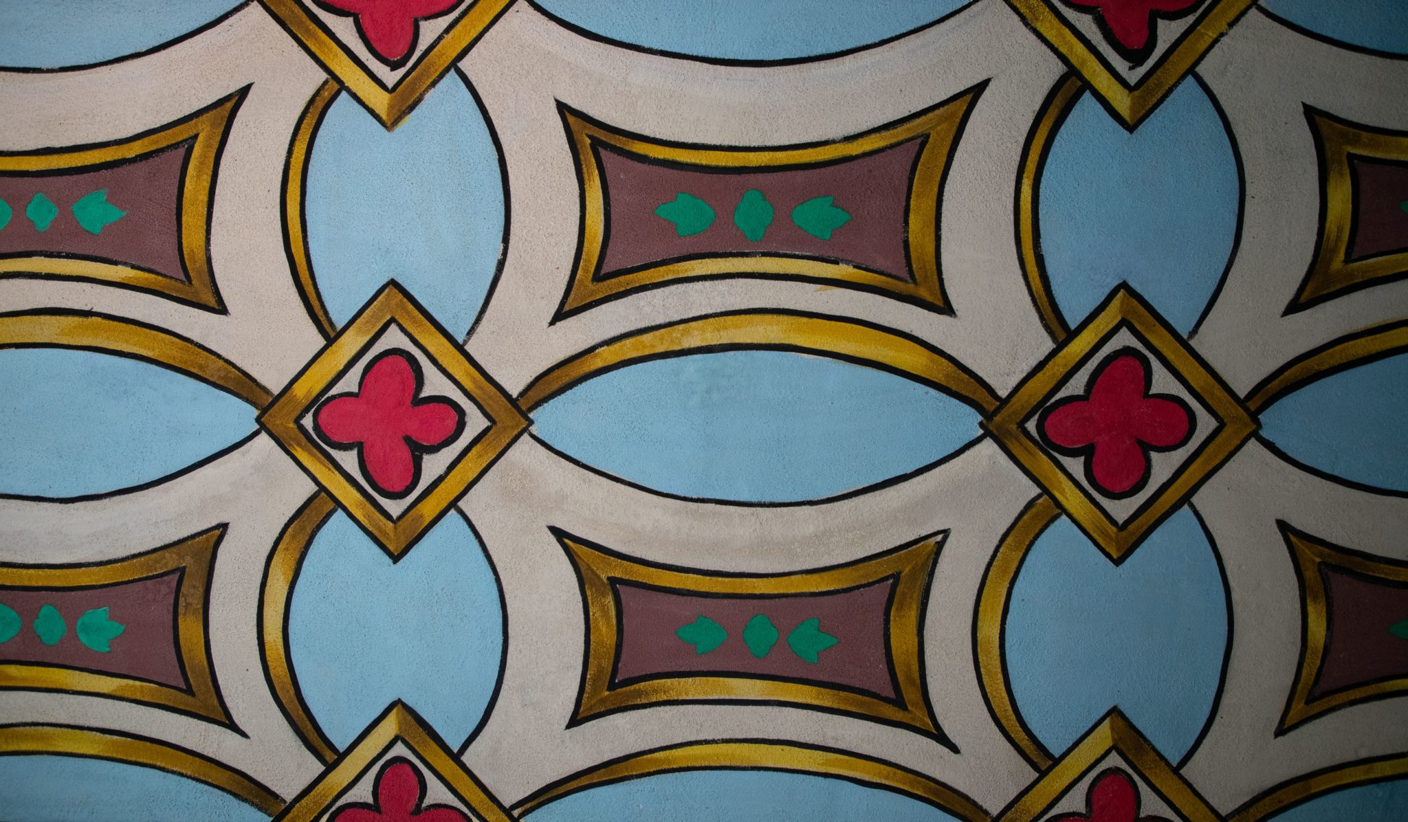 The painted pattern in blue white and red that is on the walls of the Mission Church