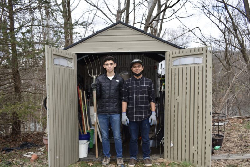 Arturo Pacheco and Zach Greenfield stand in front of a garden shed they cleaned and prepped at Wheeling University community garden.